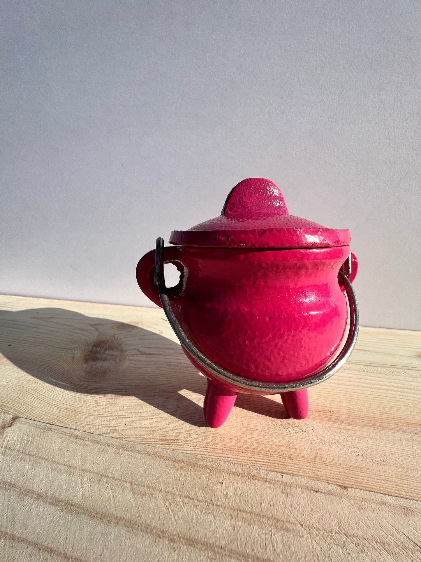 A pink cauldron with a handle.