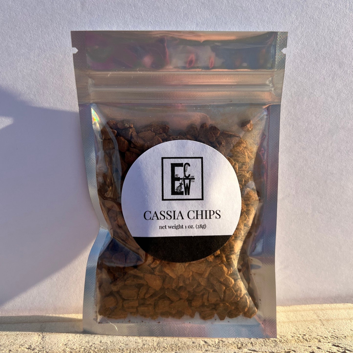 1 oz. bag of cassia chips, in a holographic bag, with a label.