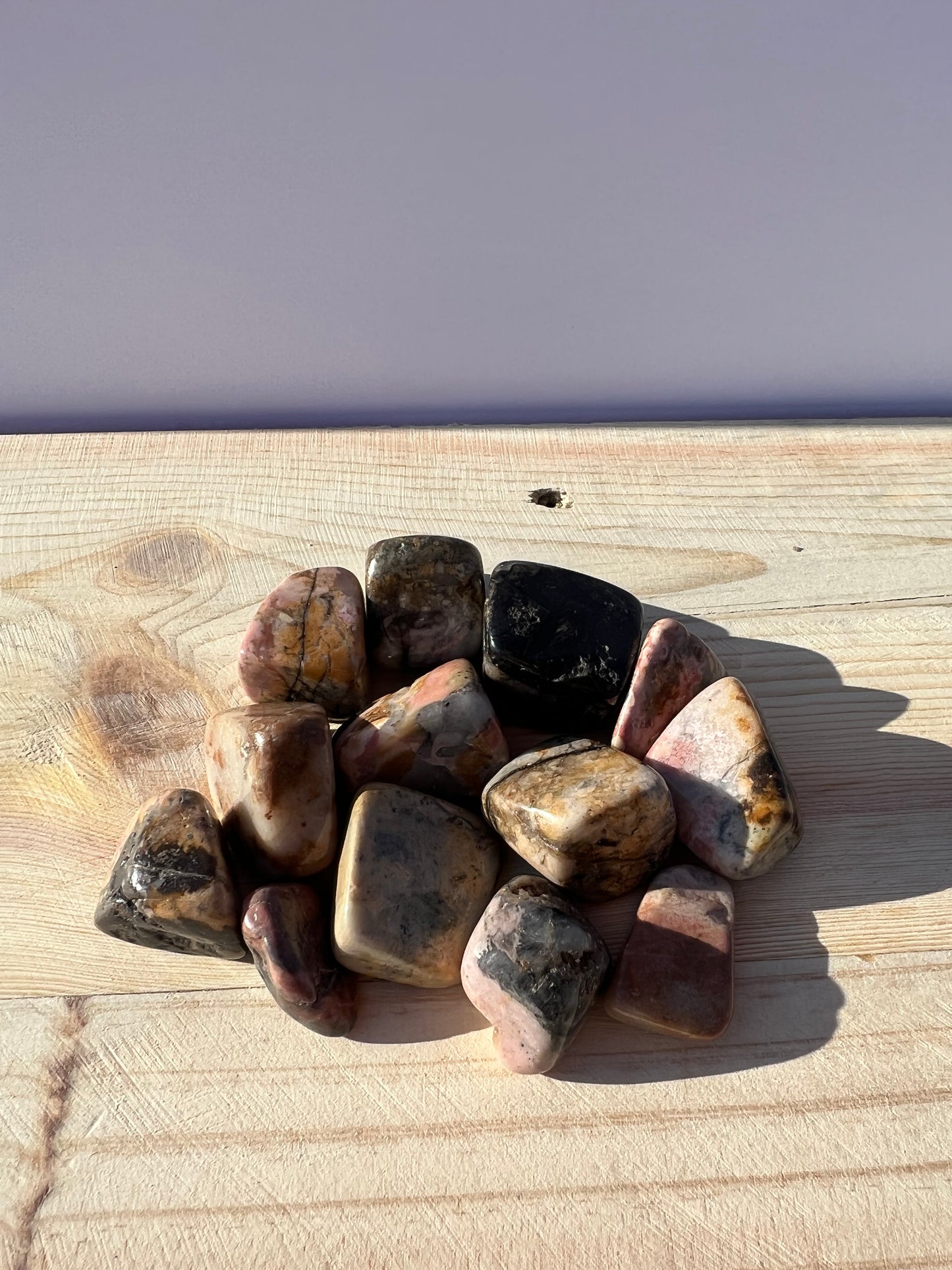 Variety of tumbled rhodonite stones